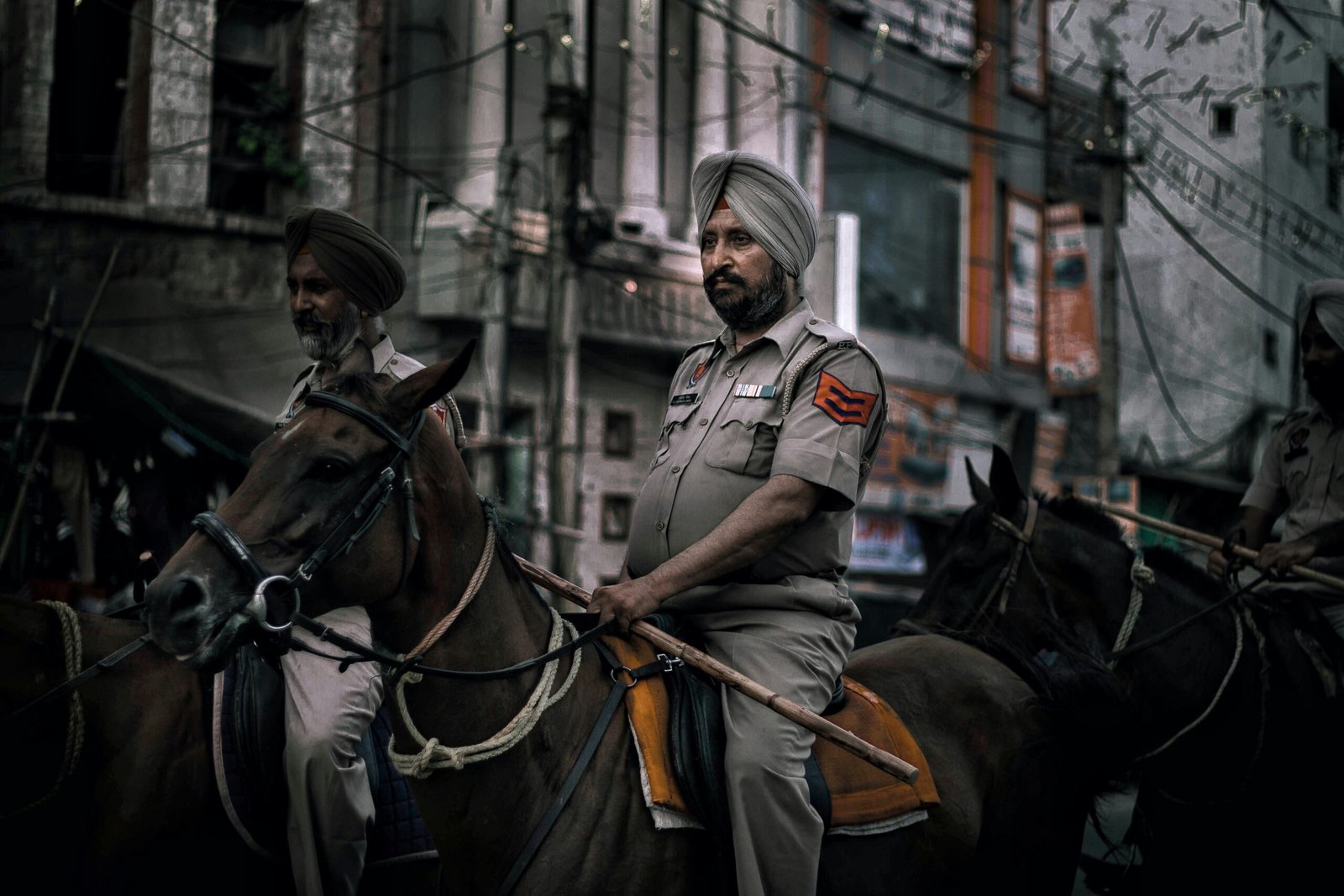 Indian police officers on horseback patrolling an urban street, symbolizing authority and the power criminals exploit in “digital arrest” scams.