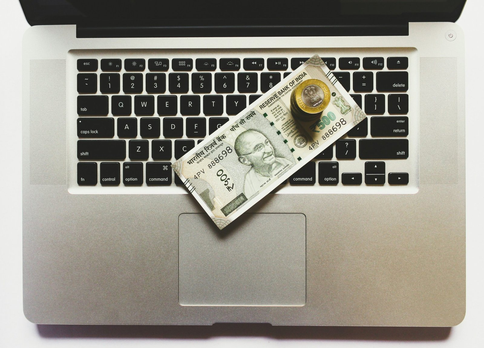Indian currency on a laptop keyboard symbolizing phishing scams and online financial fraud