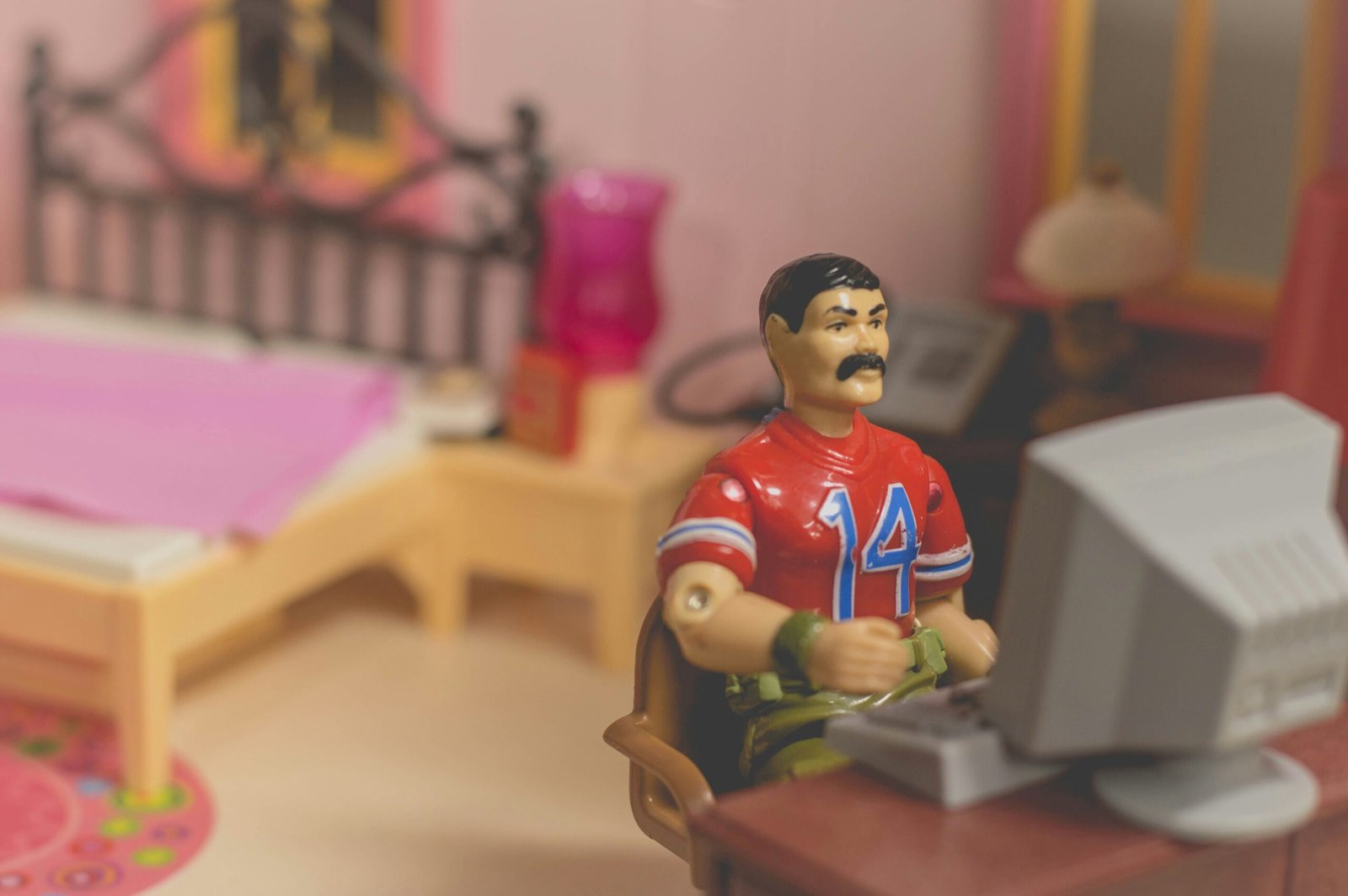 Toy figure sitting at a desk using a computer symbolizing online job application risks.